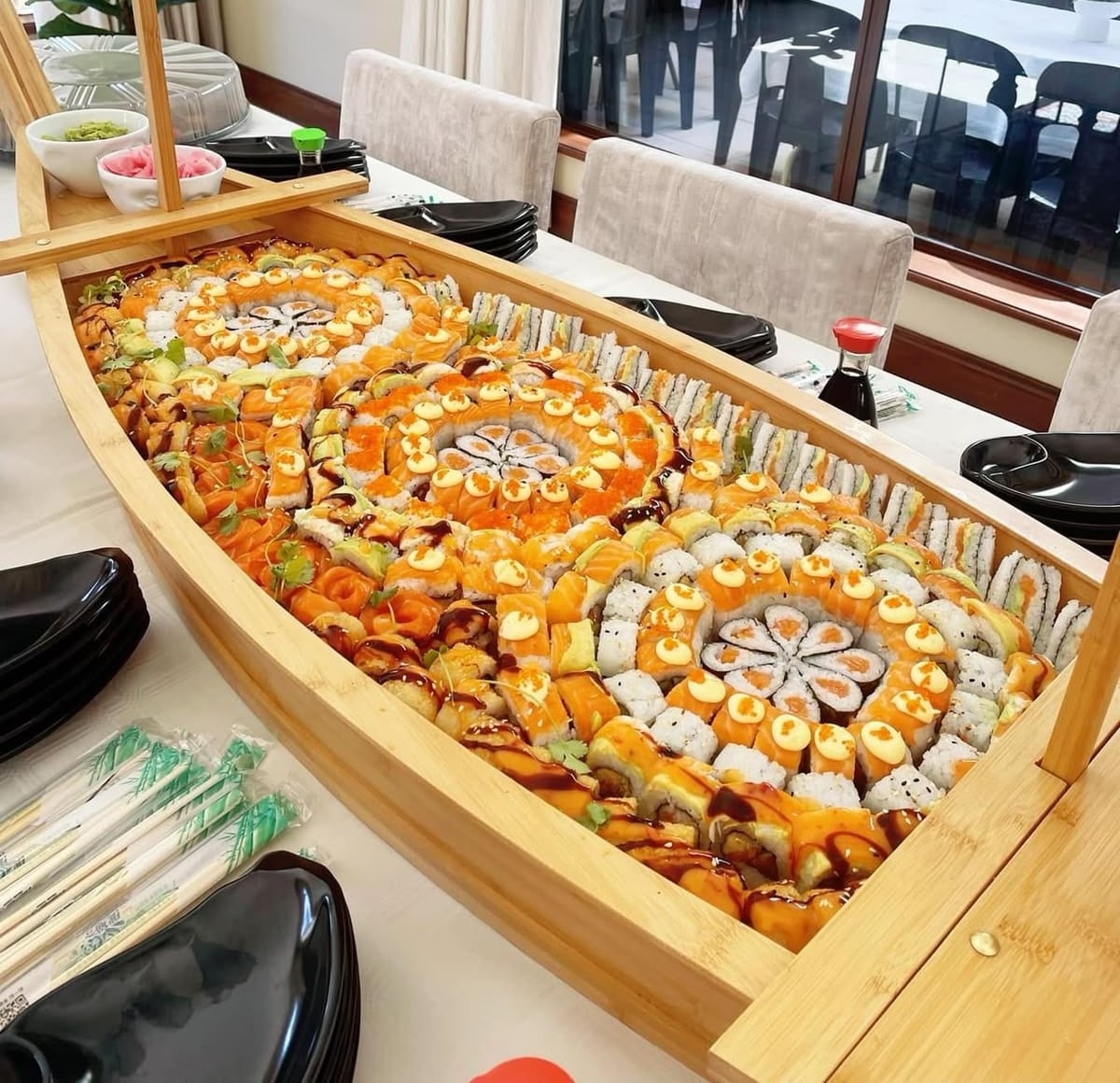 A large bamboo sushi boat filled with rolls laid out in rings