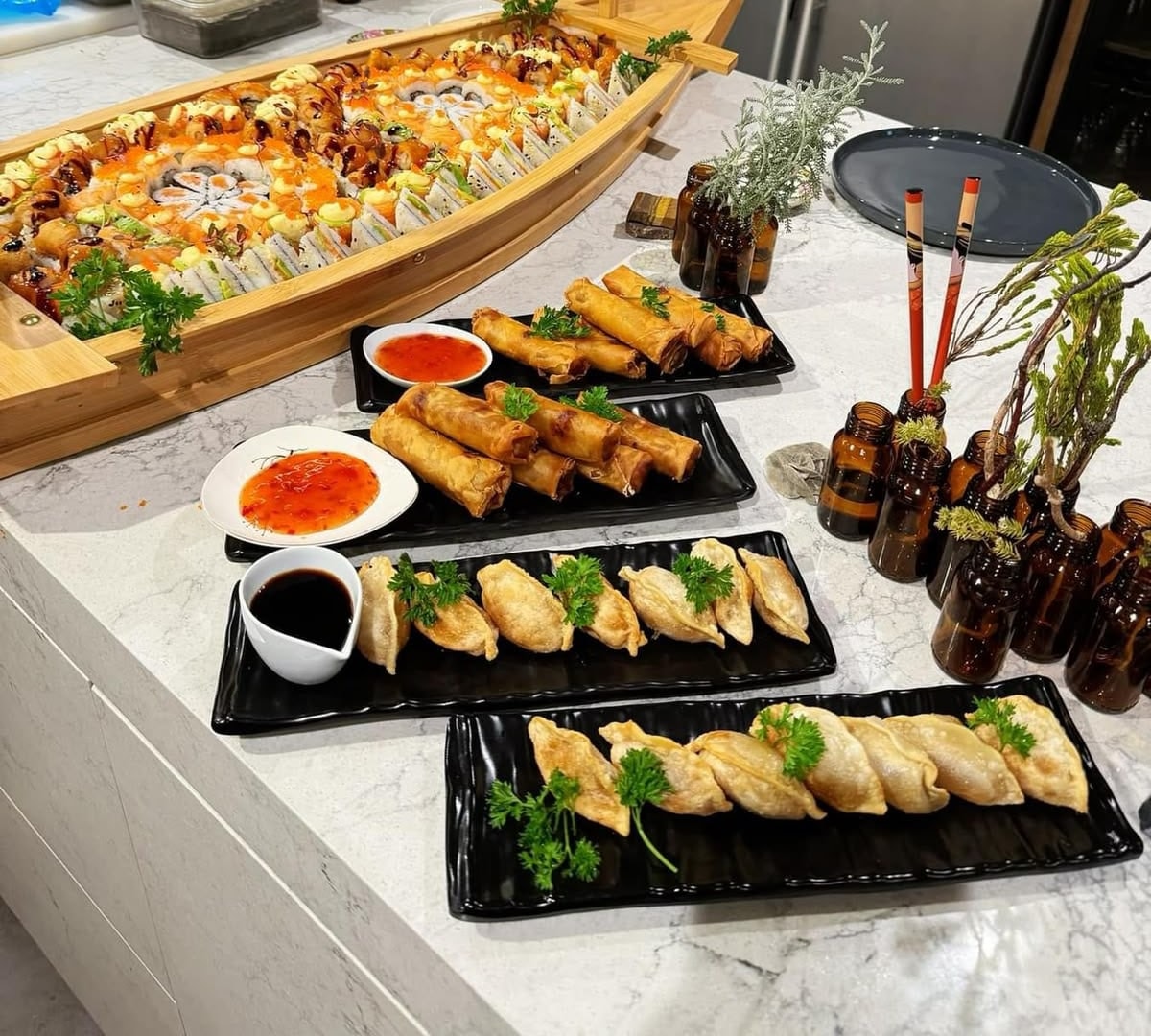 A sushi boat beside plates of spring rolls and gyoza