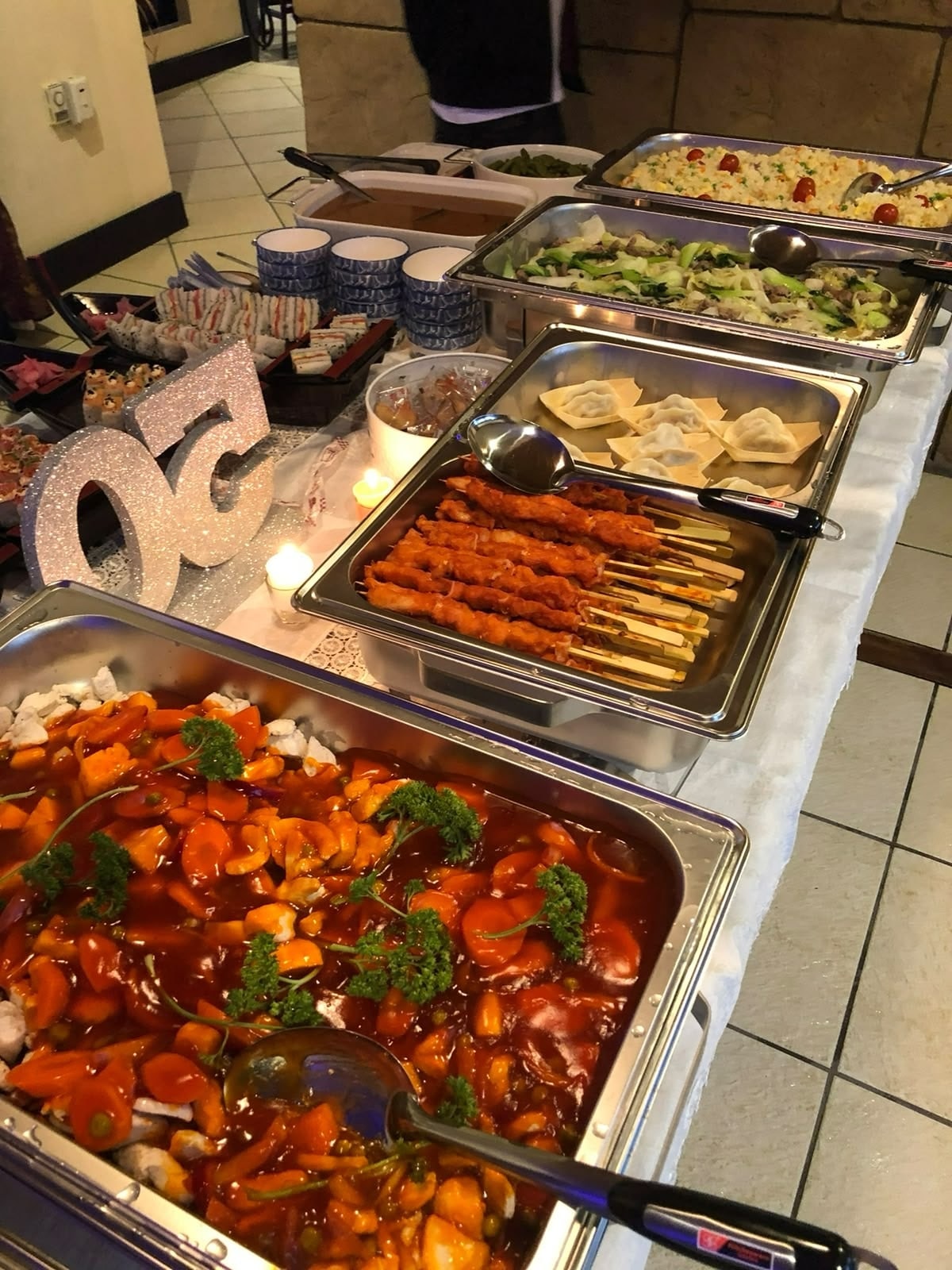Hot dishes in chafing dishes: sweet and sour, skewers, dumplings and fried rice